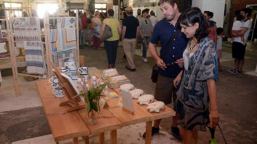 Una pareja observa uno de los puestos instalados en la Sétima Feira, en el mercado. // R.V.