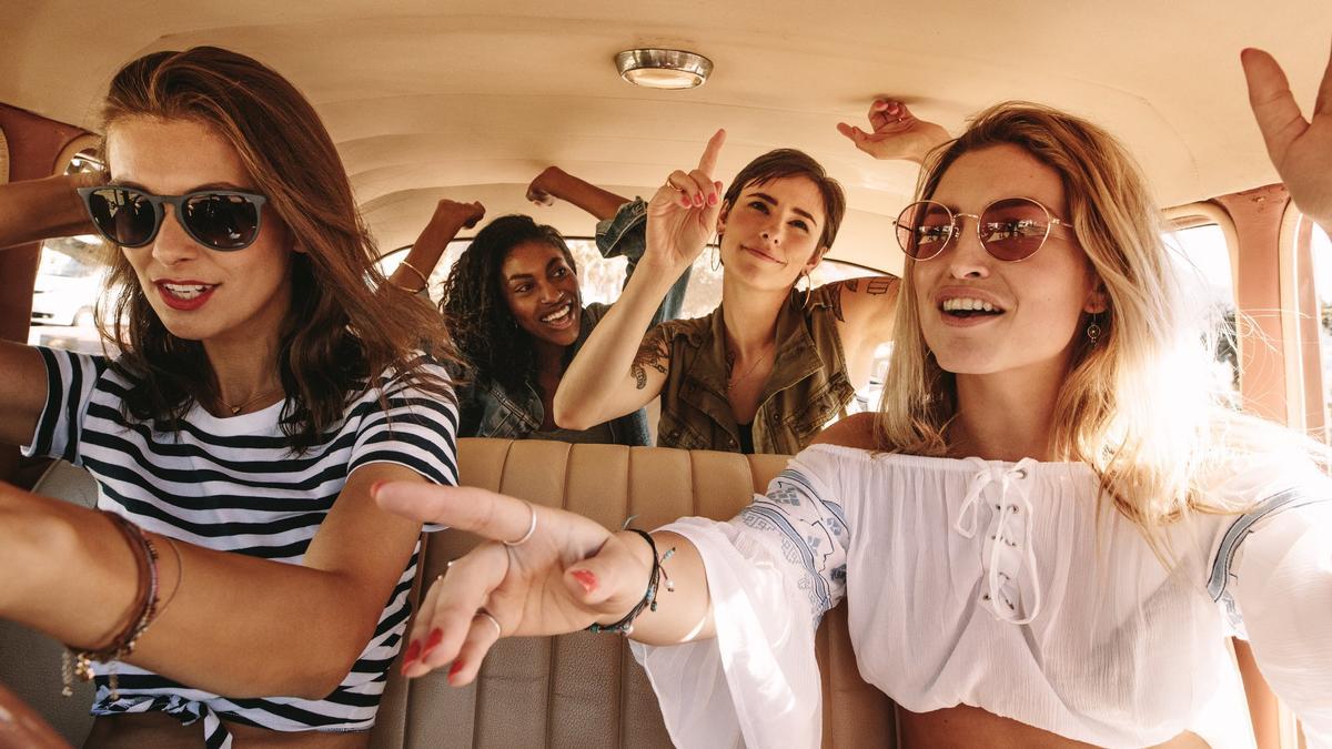 Chicas cantando y bailando en el coche