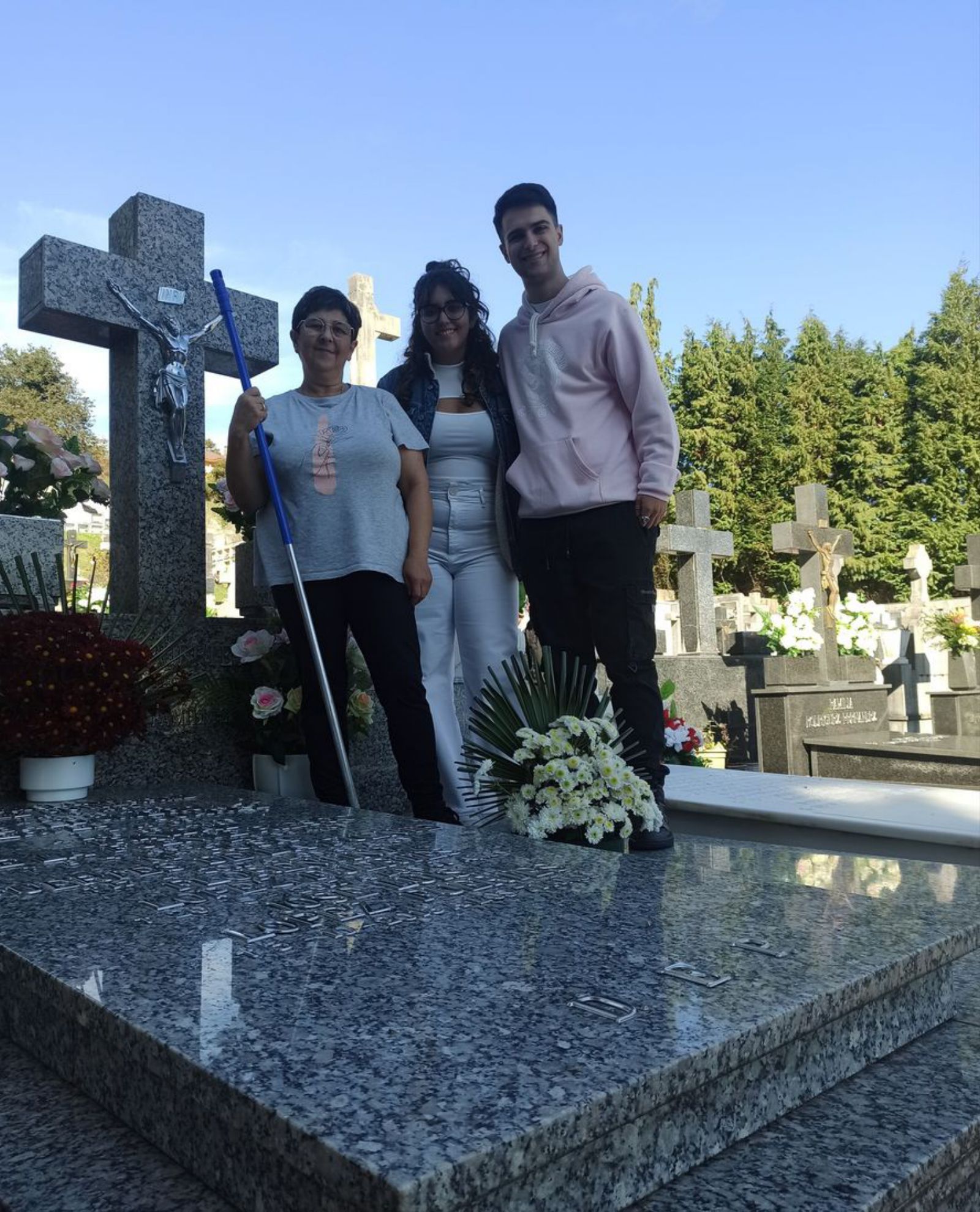 Lucía López Fuertes, Mariona Ibáñez y José Juan Iglesias, ayer, tras dejar como una patena la tumba familiar en el cementerio de Grado. | S. Arias