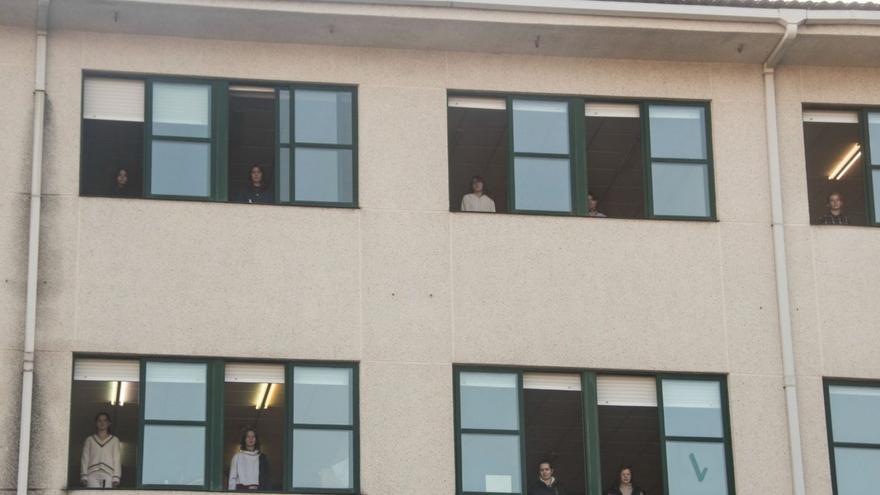 Estudiantes del IES de Chapela se asoman a las ventanas para recordar a las víctimas del machismo.