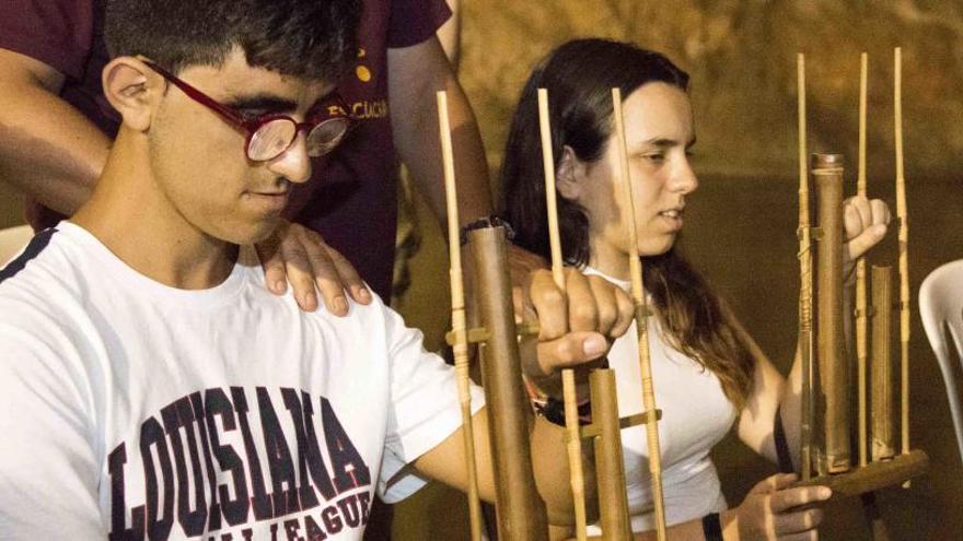 Dos jóvenes ciegos, durante el concierto con los instrumentos en las manos, preparados para tocar cuando el monitor situado detrás les presionaba en los hombros.