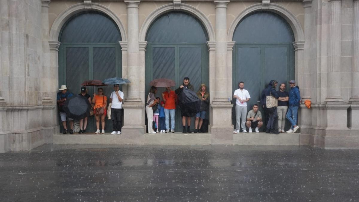 La gente se protege de la lluvia en en el centro de Barcelona