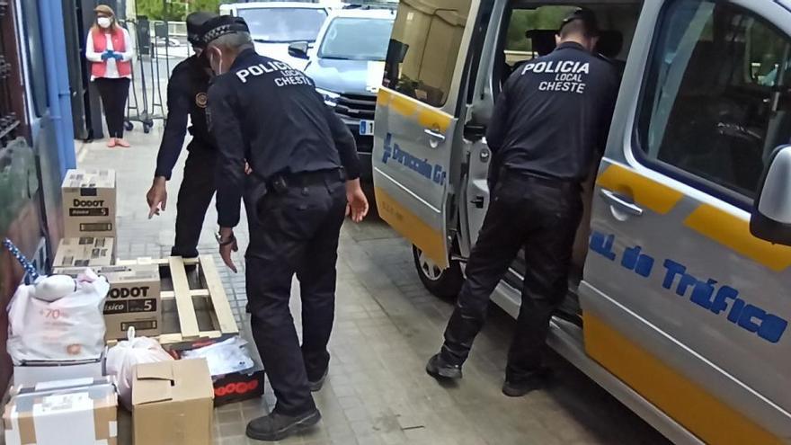 Agentes de la Policía Local de Cheste entregan el material en la Casa de la Caridad.