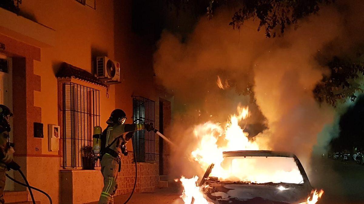 Los bomberos durante la extinción del incendio del vehículo esta madrugada