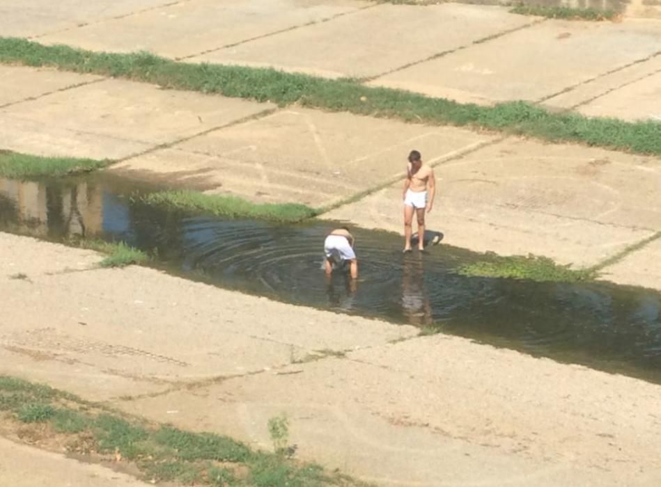 Dos joves s''han refrescat aquest dimecres a les aigües de l''Onyar al centre de Girona