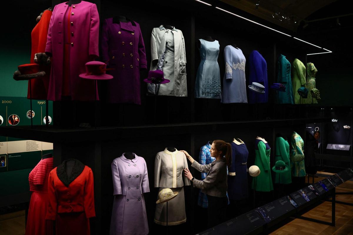 Personal de la Royal Collection Trust posa junto a un traje 'Silk Starron', de 1960.,