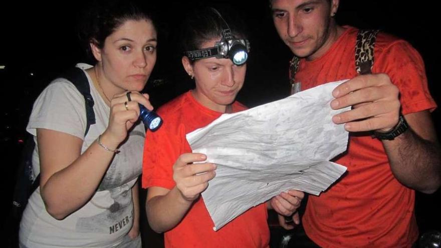 Tres participantes del &quot;rastrexo&quot; de Arcos orientándose con un mapa. // Faro