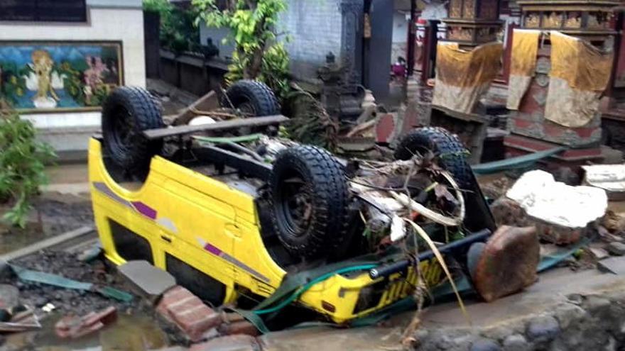 Un coche volcado tras el tsunami en Indonesia.