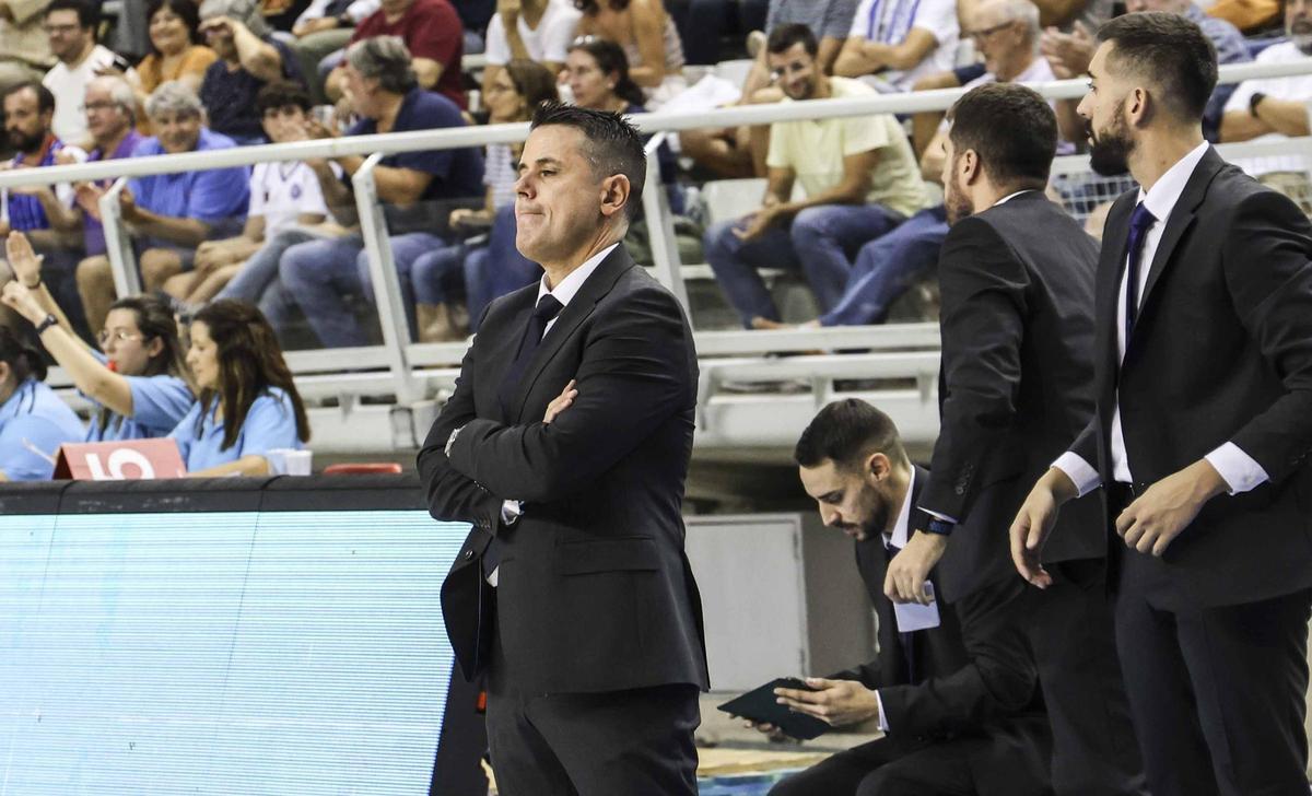 Carlos Rubio utiliza la tablet mientras Pérez Caínzos observa el desarrollo del partido, delante.
