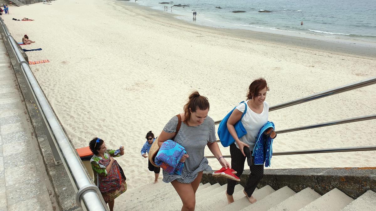 Gente abandonando la playa viguesa de Samil ante el mal tiempo.