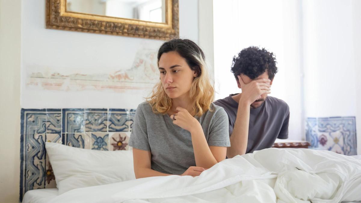 Pareja tóxica discutiendo en la cama.