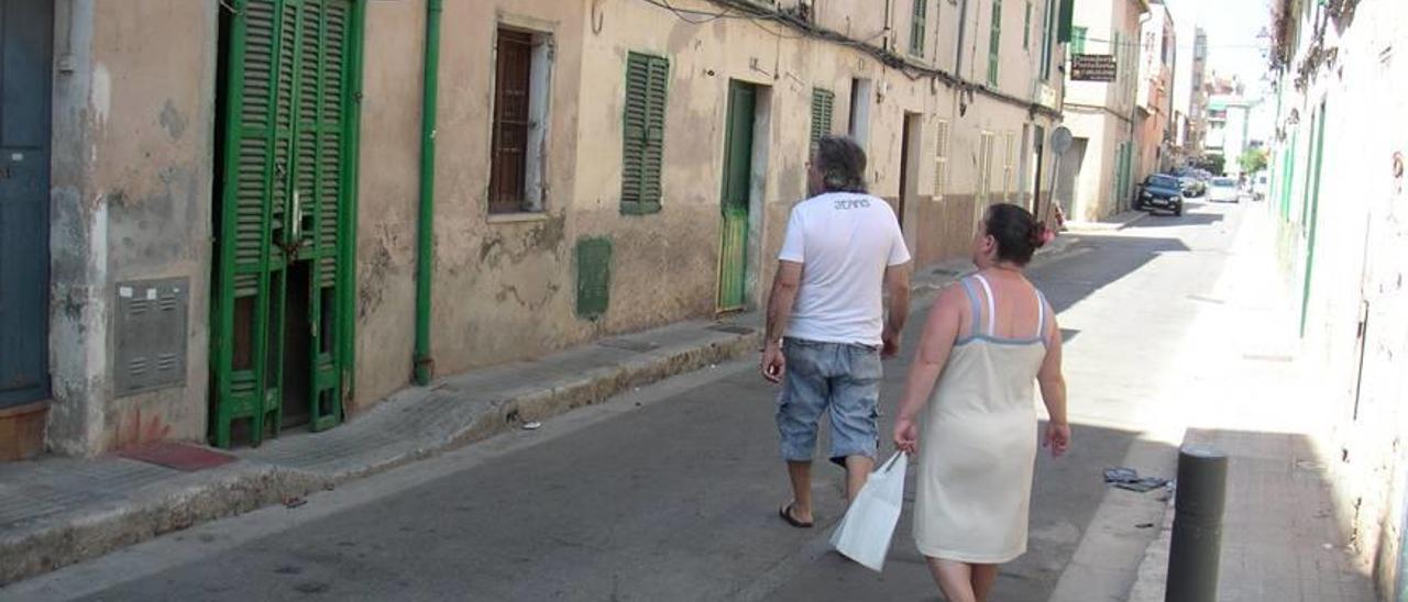 Dos personas caminan por una calle del barrio palmesano de La Soledat.