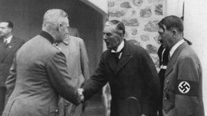 El primer ministro británico Chamberlain saluda al general alemán Keitel en su visita a la residencia de descanso de Hitler (a su izda.) en 1938.