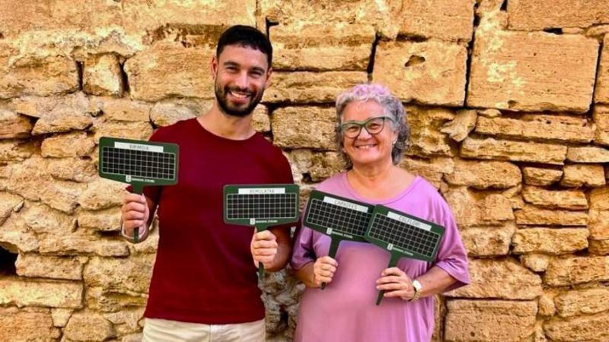 Los responsables de Normalización Lingüística, con la regidora Carme Garcia, muestran algunos de los carteles repartidos en los mercados.