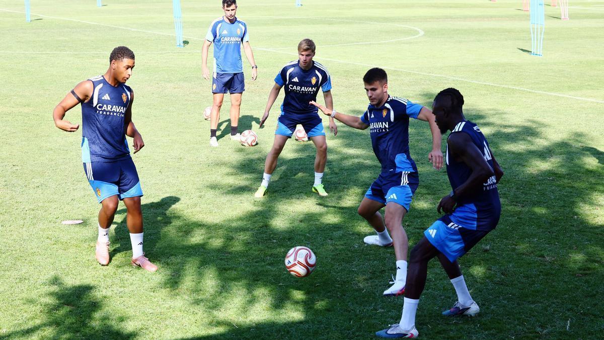 El jugador del filial Laken Torres, Emil Hansson y Peter Ademo tocan en rondo en el entrenamiento en Villaboya.