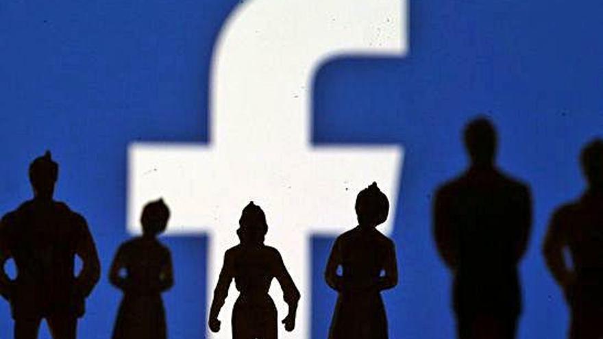 Sombras de varias personas frente al logotipo de Facebook.