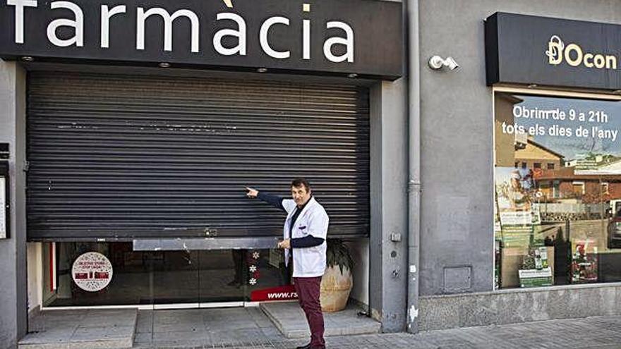 El farmacèutic mostra la persiana que els van destrossar.