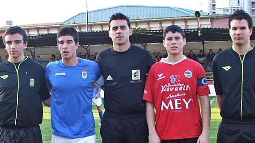 el actual jugador de la UD y entonces capitán del Laredo, posa junto a un jugador del Real Oviedo y el trío arbitral antes del partido, ese mismo curso. 