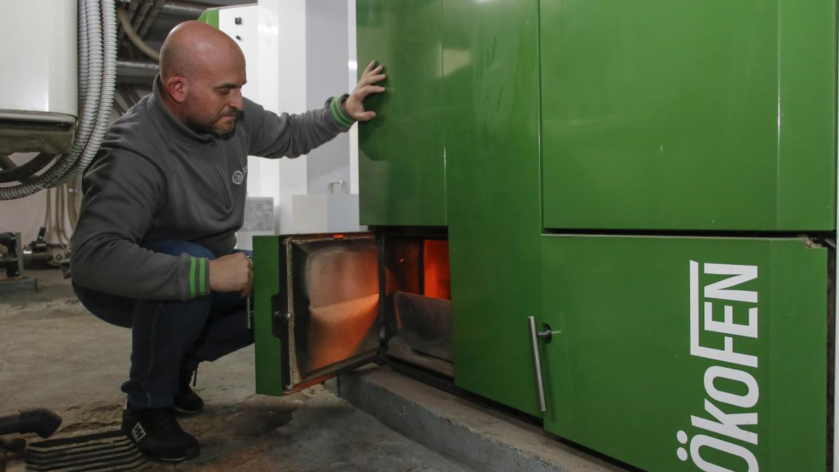 Técnico revisando la cámara de combustión de una caldera de pellets.