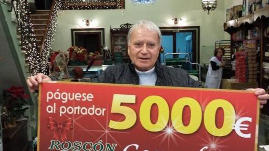 Rosendo Suárez posa en la confitería con el cheque