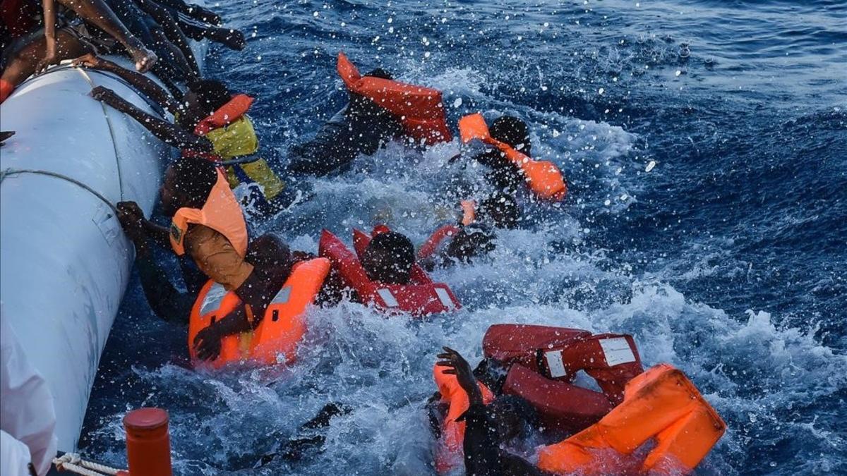 Inmigrantes y refugiados dominados por el pánico durante una operación de rescate dirigida por la oenegé maltesa Moas y la Cruz Roja italiana, frente a las costas de Libia, este jueves.