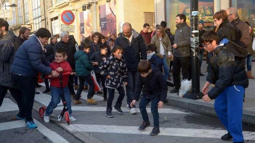 Niños y mayores recogen caramelos. // Noé Parga