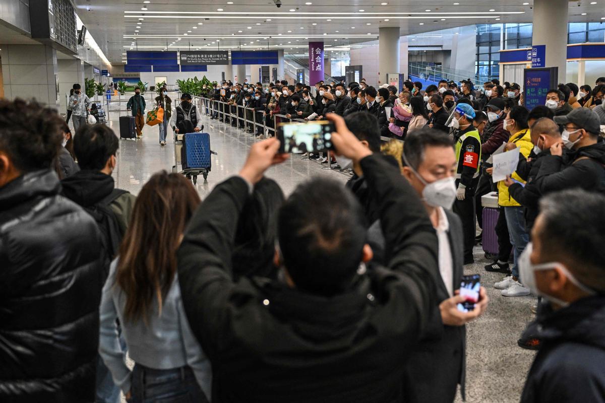Pasajeros a su llegada al Aeropuerto Internacional de Shanghái Pudong en Shanghái al levantar los requisitos de cuarentena para los viajeros.