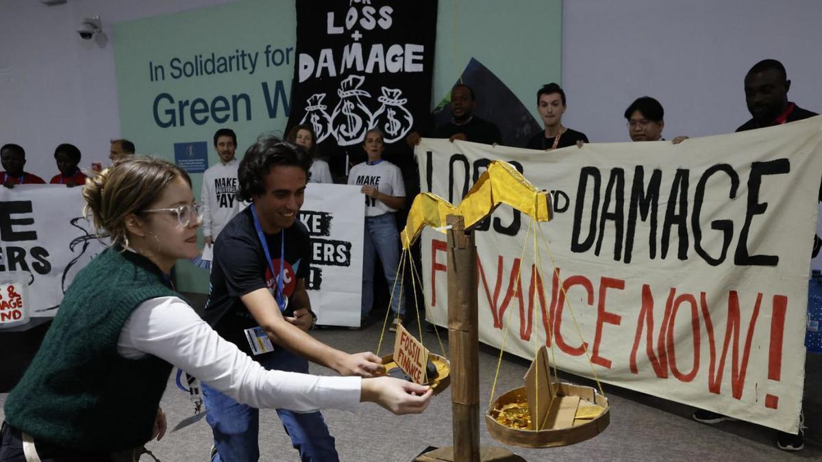 Activistes climàtics portant a terme una acció de protesta ahir en la cimera de Bakú.