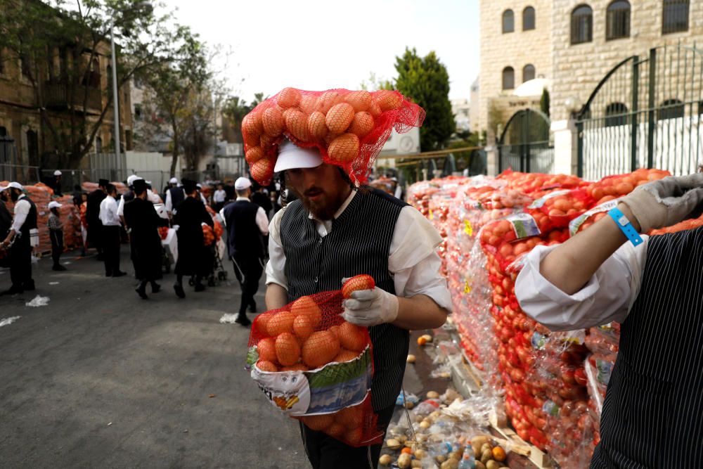 Un judío ultraortodoxo lleva sacos de patatas a un centro de distribución de alimentos que ofrece productos alimenticios para las familias antes de la próxima festividad judía de la Pascua, cerca del barrio Mea Shearim de Jerusalén.