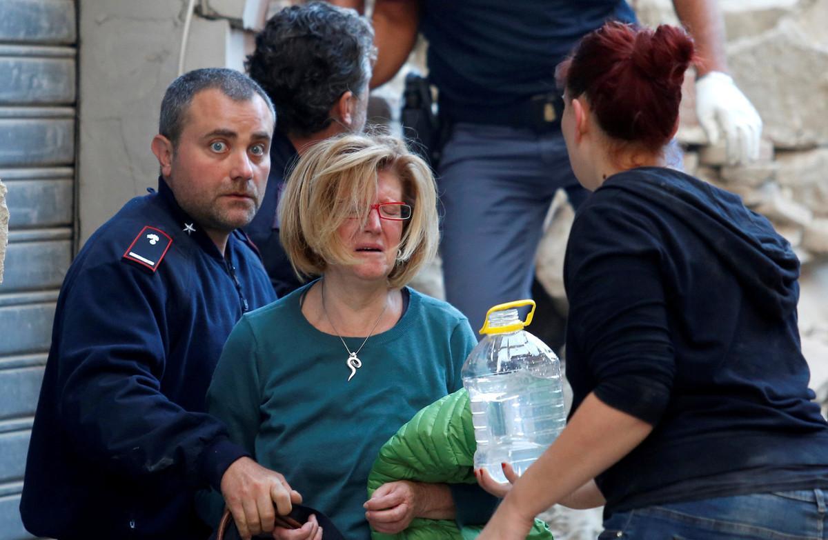 A woman (2nd L) cries after been rescued from her home following a quake in Amatrice, central Italy, August 24, 2016. REUTERS/Remo Casilli     TPX IMAGES OF THE DAY