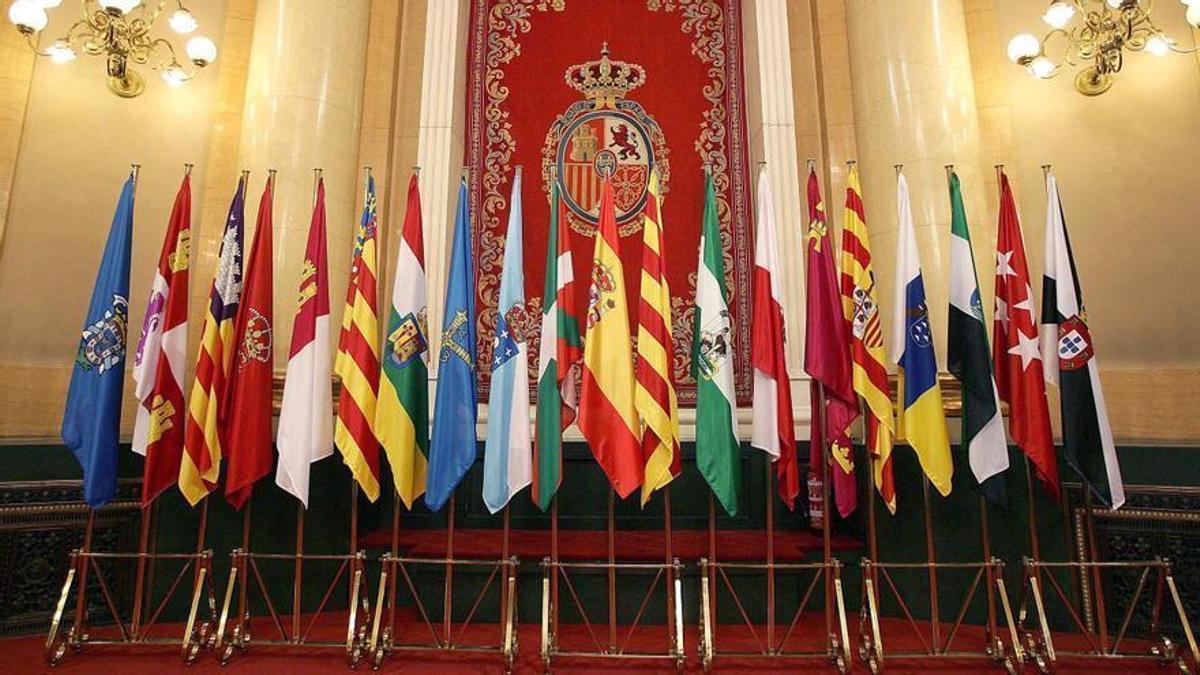 La bandera nacional y las distintas banderas autonomicas colocadas en el antiguo salòn de plenos del Senado.