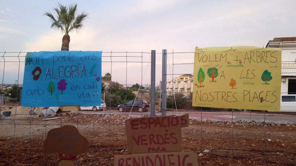 Carteles colocados por los vecinos en la valla de la plaza en obras