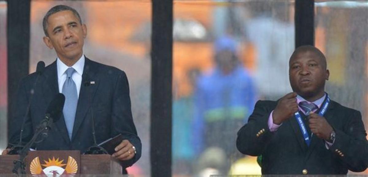 Obama al costat del fals intèrpret de la llengua de signes, a l’escenari de l’estadi de Soweto, aquest dimarts.