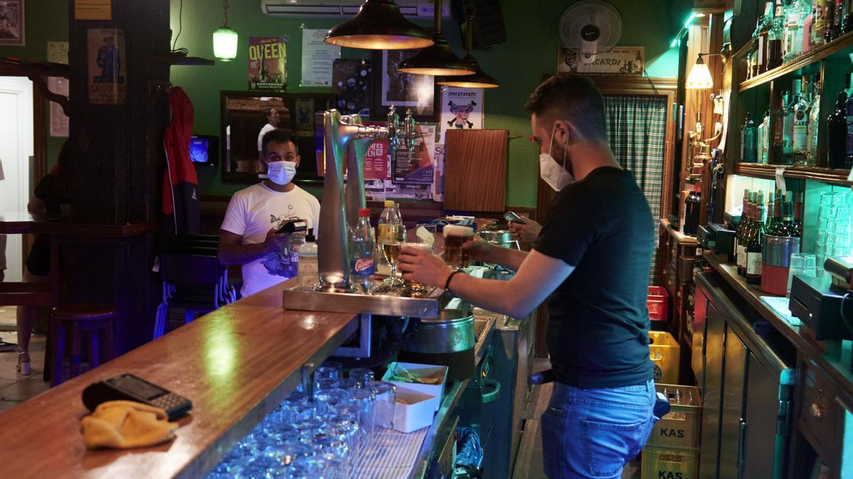 Una camarero sirve una cerveza en un bar.