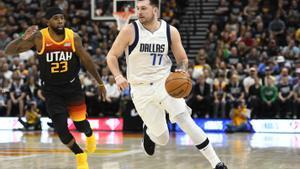 Doncic conduce el balón, perseguido por el base de los Jazz, Mike Conley