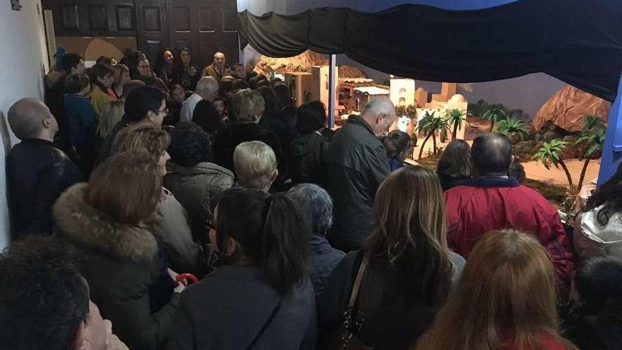 Vecinos y visitantes admiran el belén parroquial de Vega durante su inauguración, ayer.