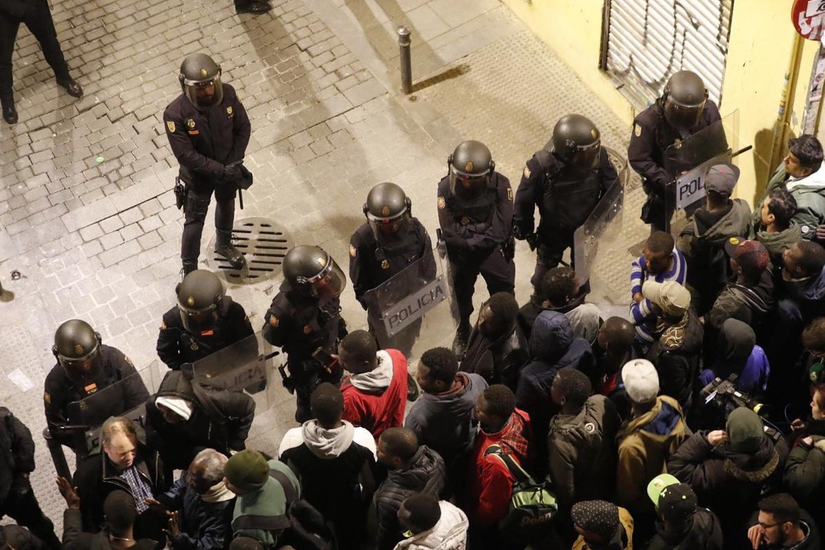 GRAF3166  MADRID  15 03 2018 - Policias antidisturbios intentan calmar la tension en la calle Meson de Paredes con la calle del Oso  en el barrio de Lavapies de Madrid  tras la muerte de un mantero de un paro cardiaco durante un control policial contra el top manta en el barrio de Lavapies de Madrid  Tras el suceso  se han concentrado decenas de personas en protesta contra la presion policial que existe en la zona contra los vendedores del top manta  EFE JAVIER LIZON