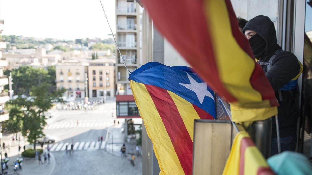 Miembros del CDR descuelgan la bandera española de la Delegacio Del Govern en Girona