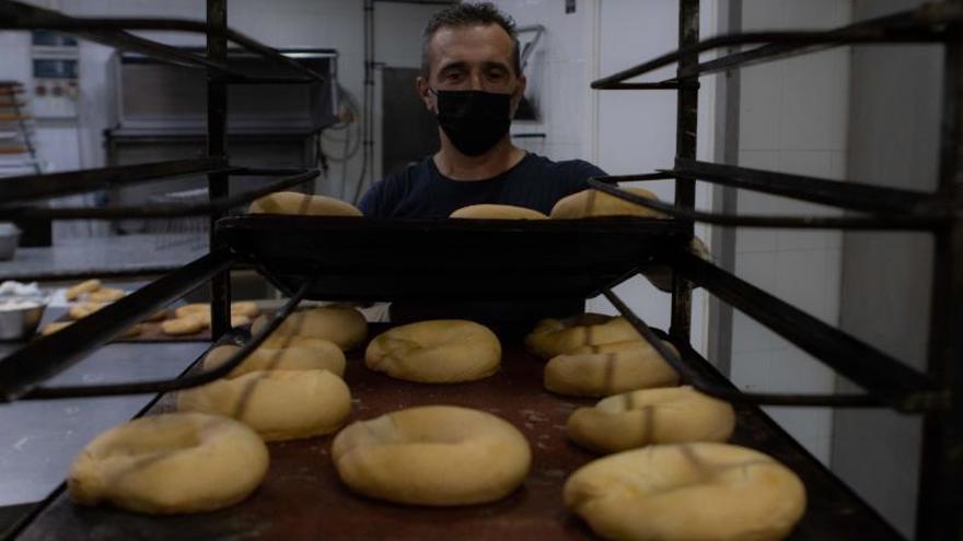 El panadero prepara la primera remesa de los típicos rollos de pan de San Ginés en la confitería del barrio con el nombre del patrón. | 
LOYOLA PÉREZ DE VILLEGAS