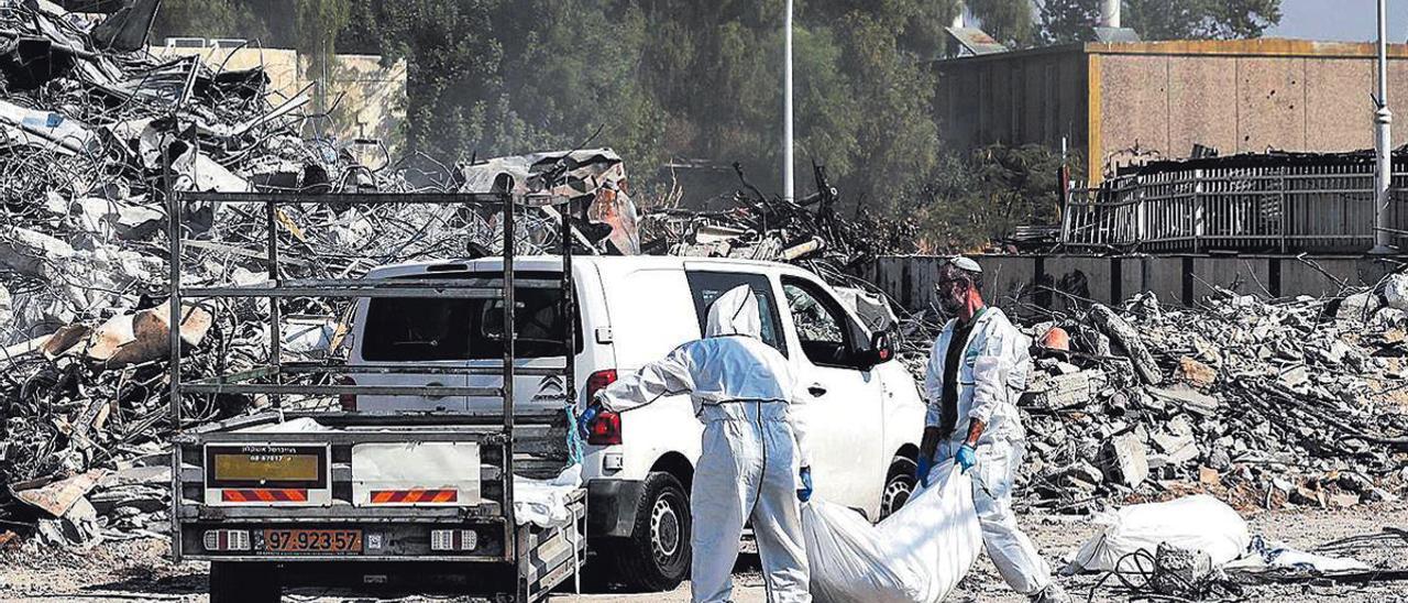 Trabajadores de los equipos de rescate israelí recuperan cuerpos cerca de la comisaría de policía de Sderot