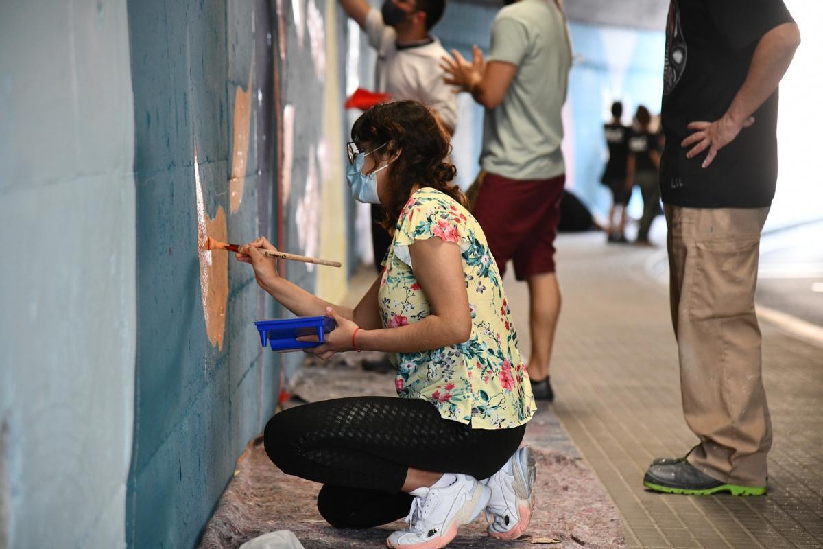 Joves espluguins pinten un mural al túnel del carrer Ignasi Iglesias