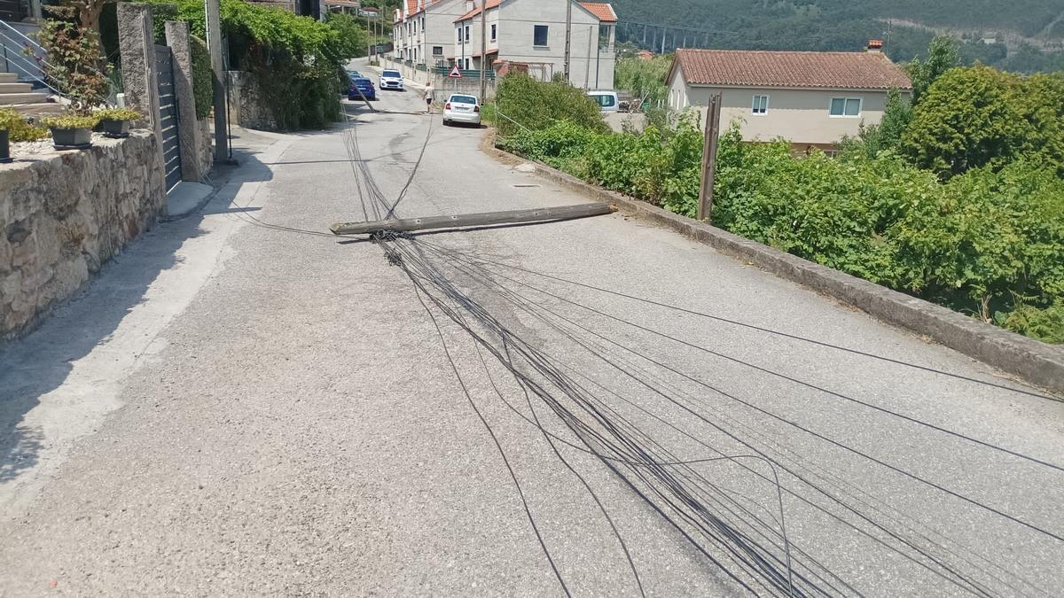 Los cables tirados en el vial de Palmás y el coche de la Policía Local.