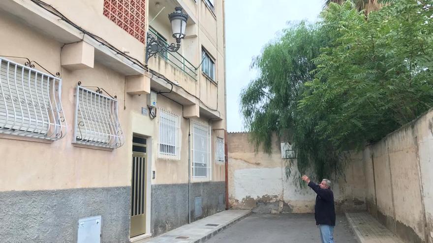 Juan Romero señalando la fachada del piso donde vive y por la que en las noches de verano deambulan las salamanquesas en busca de insectos.