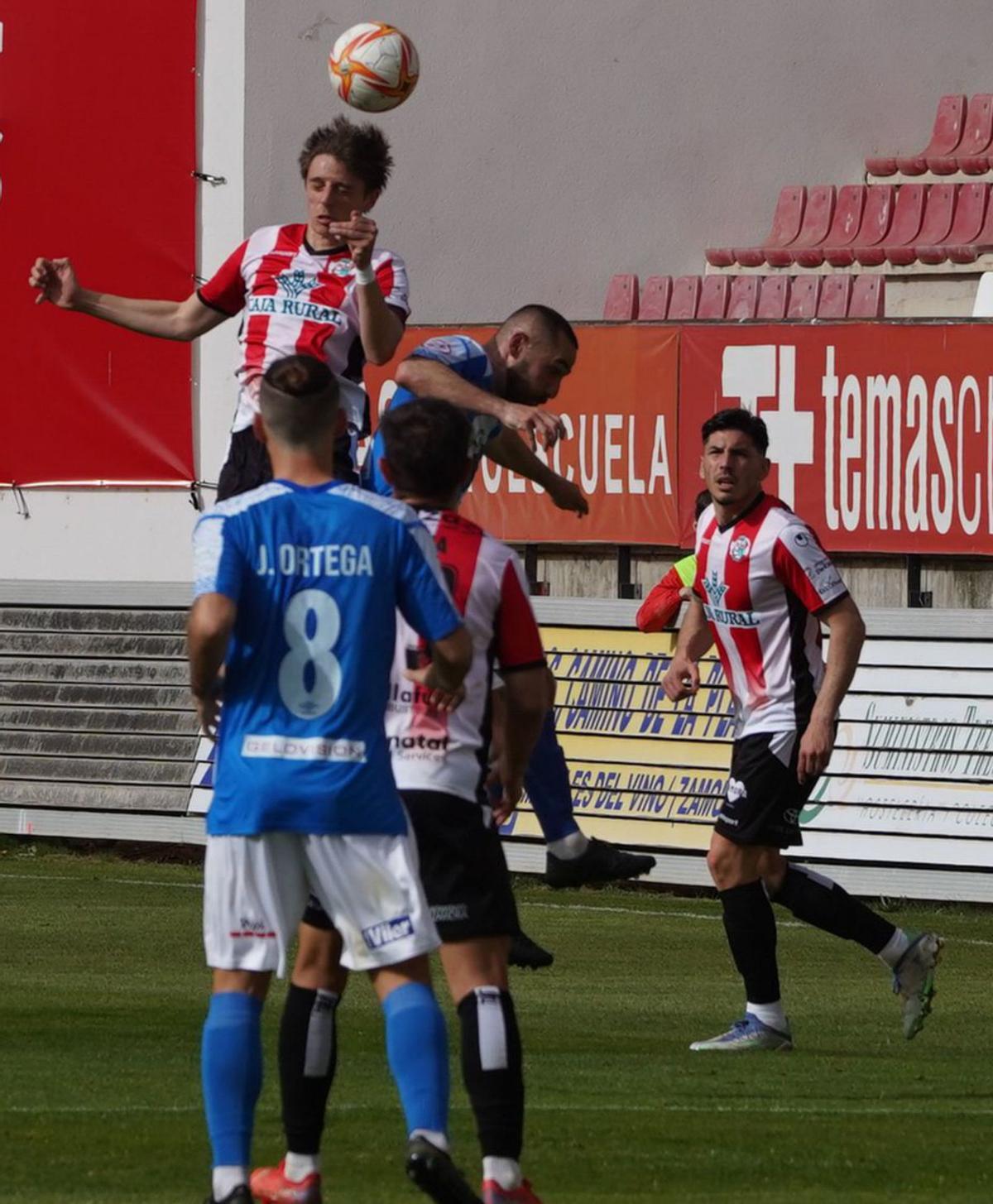 Luque remata de cabeza, y los jugadores del Talavera celebran el gol.  / José Luis Fernández