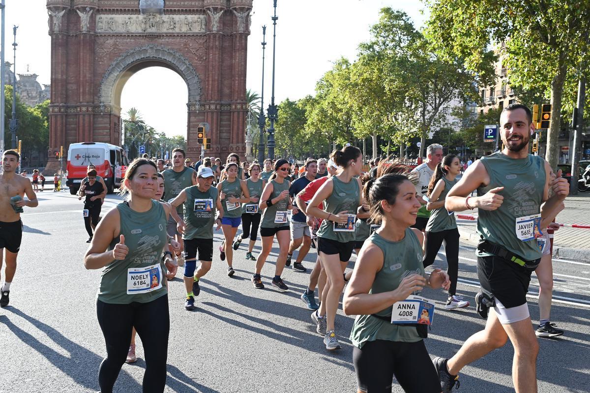 Los participantes en la Cursa de la Mercè a su paso por el  Arco del Triunfo. 