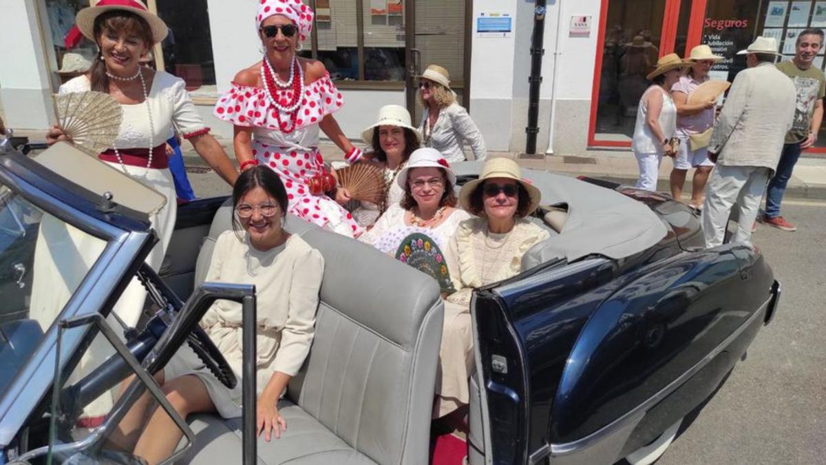 Participantes subidos a un coche antiguo.