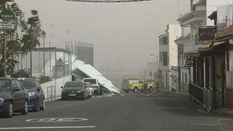 La estructura metálica, sobre el vallado de la cancha de futbito y los vehículos en Firgas.