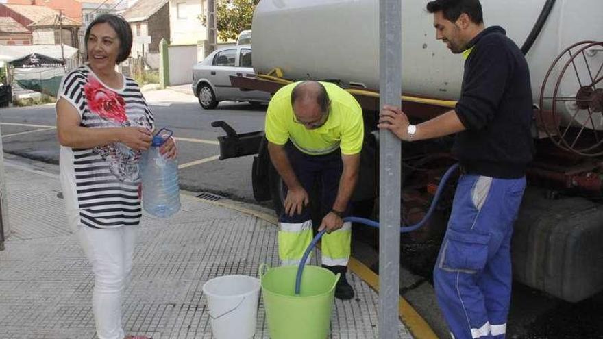 Un camión cisterna del Concello de Marín abastece a los vecinos de Seixo que tienen que recoger el agua en cubos. // S. A.