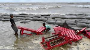 Los niños empujan sillas de playa hasta la orilla del mar como medida preventiva durante las lluvias en Kuakata el 26 de mayo de 2024, antes de la llegada del ciclón Remal a Bangladesh .