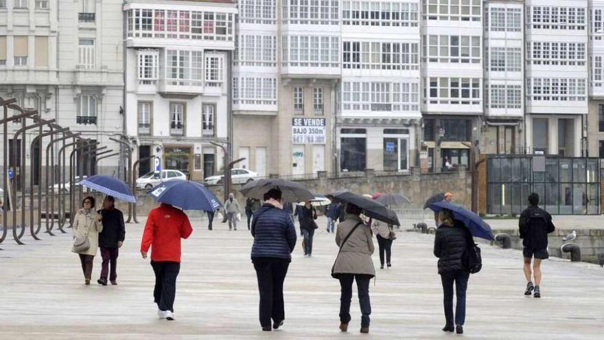 Gente paseando con paraguas ayer por la tarde en A Coruña.